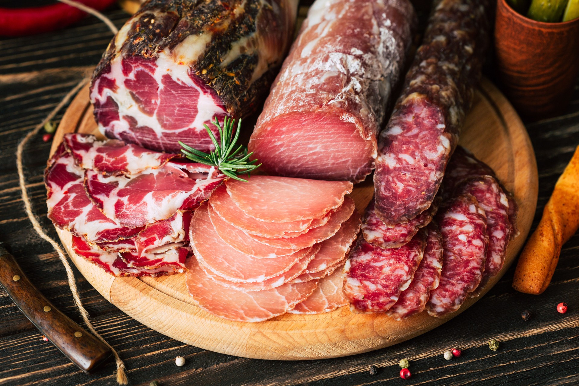 meat delicacies on wooden background, dried sausage on a cutting board